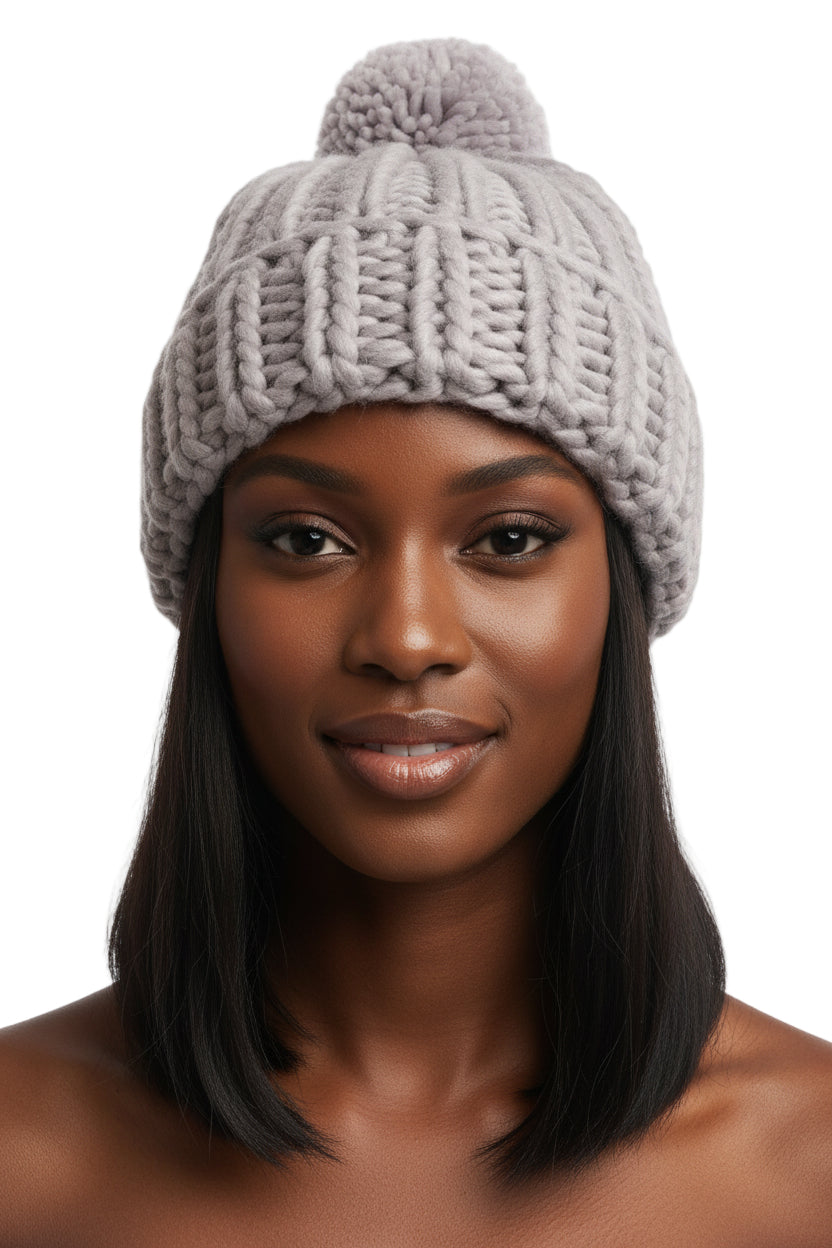 Woman wearing a gray knit beanie with a pom-pom on a white background