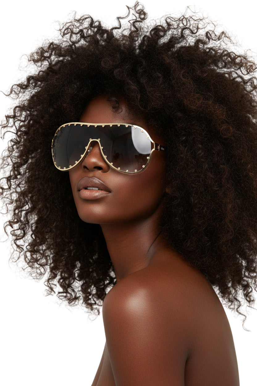 A pair of gold-colored metal aviator sunglasses with a stud design on the arms and a gradient lens.