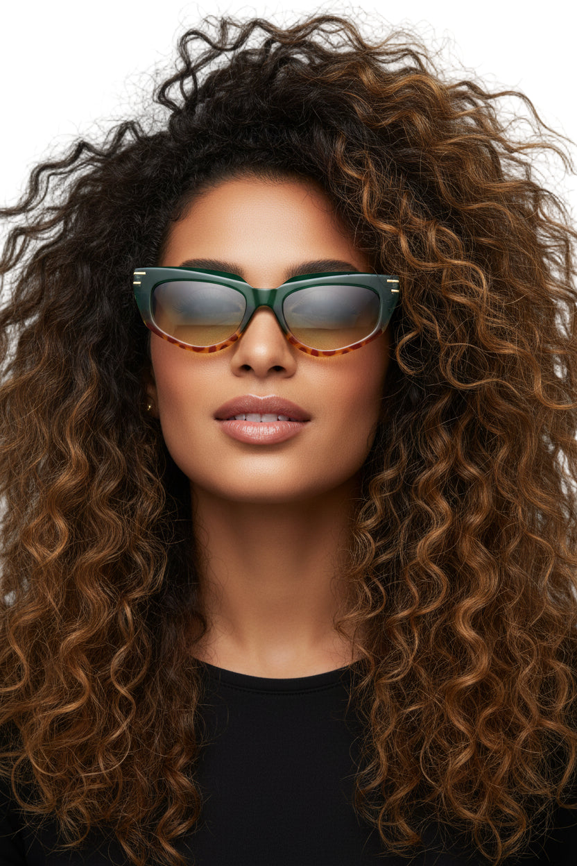 A pair of green sunglasses with gold trim and detailed gold accents on the arms.