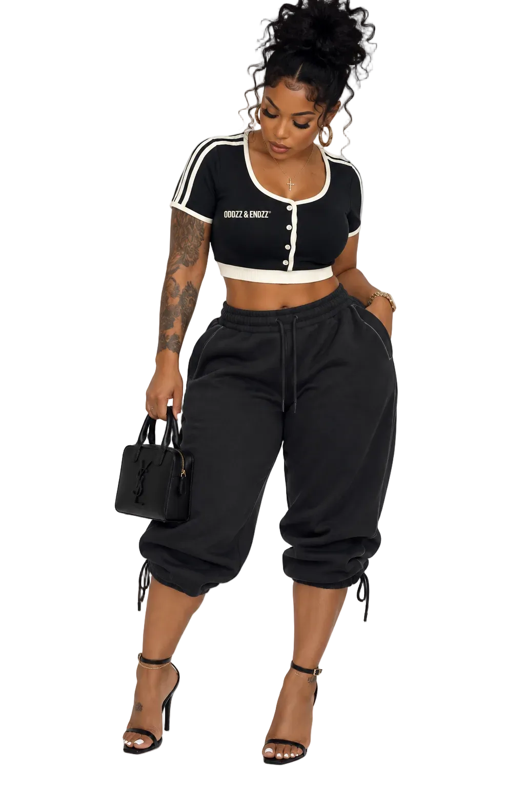 Black female model wearing Oddzz & Endzz® black and cream contrast trim crop top styled with capri sweatpants and heels