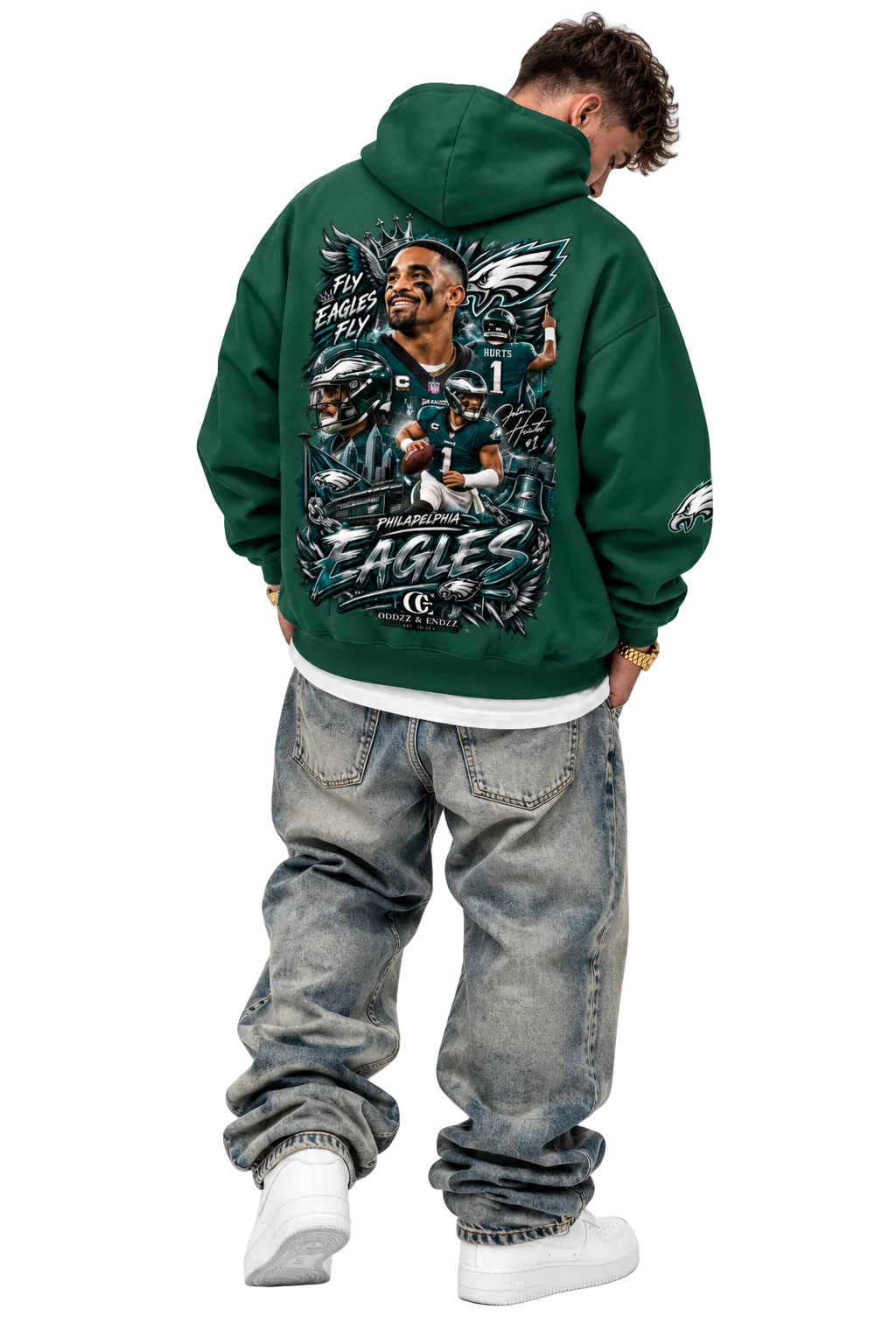 A man shown from the back wearing a dark green Philadelphia Eagles hoodie with a large graphic print on the back, paired with faded blue jeans and white sneakers, against a plain white background.